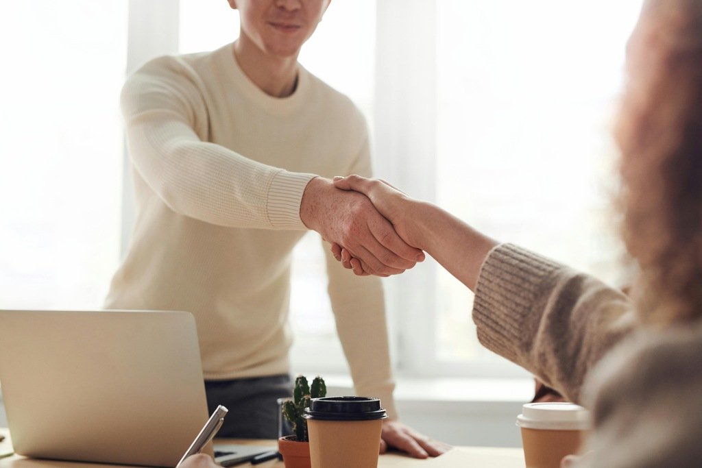 Aperto de maos selando uma parceria comercial